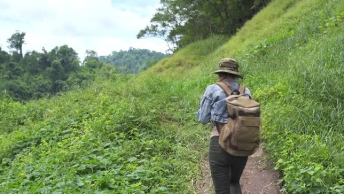 4k亚洲女性背包客在溪边的山路上徒步旅行