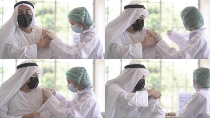 阿拉伯穆斯林男子的肖像坐在诊所或医院接种covid疫苗，手持护士注射疫苗以获得免疫力，以保护病毒。病