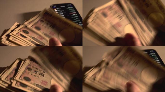 人喜欢手里拿着现金。男人数10,000日元钞票。他手中的智能手机显示市场价格。