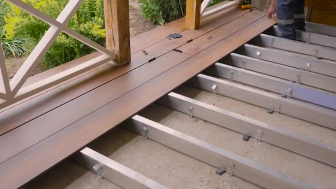 地板安装工程建筑商建筑露台。装修房。露台上的甲板木板。木地板覆盖物。修理木板连接的家庭甲板地板。在露