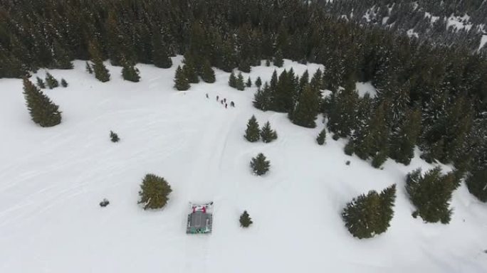 在雪坡上行驶的雪猫ratrack鸟瞰图，滑雪道外斜坡上的生命救援紧急情况，山区滑雪事故