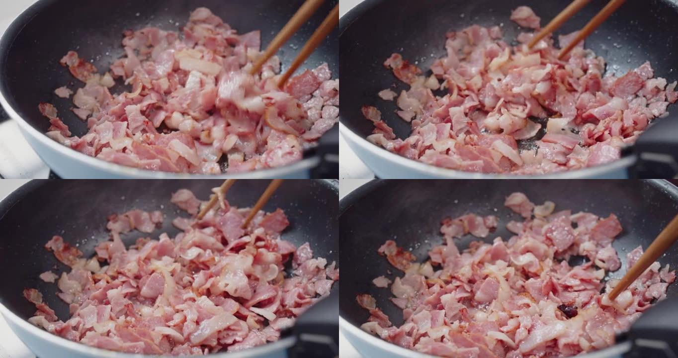 将切碎的脆皮培根切片放在热锅煎锅中，热油爆炸飞溅，富含脂肪和颜色，炙手可热的肉类食品