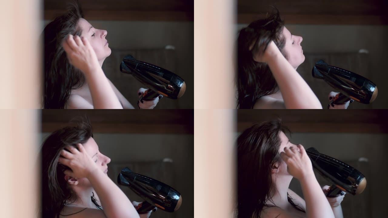 镜子附近浴室里的电影漂亮黑发女人用吹风机吹干头发，头发飘动