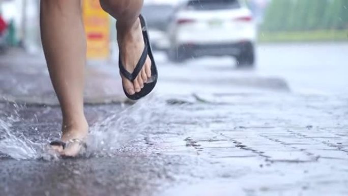 下雨天跑步活动的低角度镜头，在街上散步，洪水泛滥的街道，匆忙奔跑寻找避难所遮雨，季风台风季节，湿透身