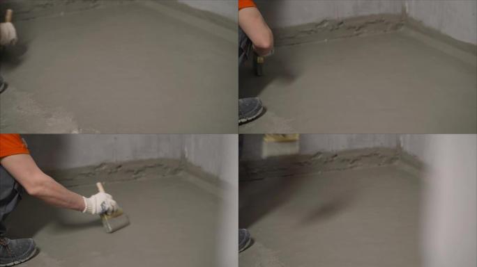 工人用砂浆覆盖混凝土熨平板并进行防水处理。用解决方案对地板进行防水处理的过程