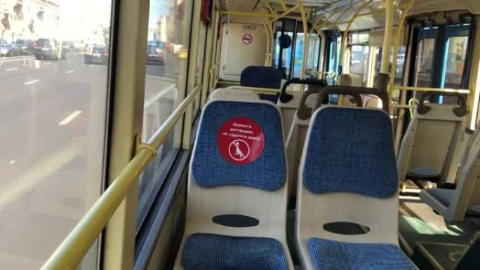 公共巴士内部，座位上贴有遵守社会距离的贴纸