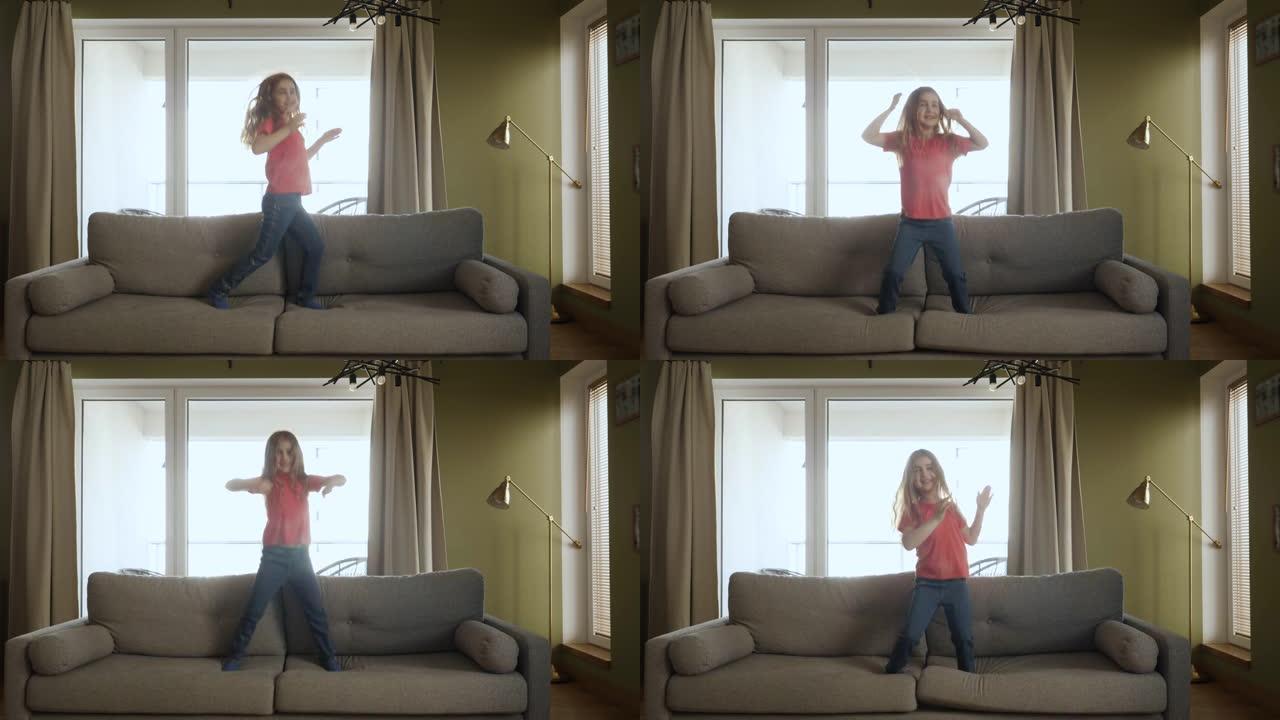 有趣快乐的小女孩正在家里的沙发上跳舞和跳跃。女儿在客厅玩耍。热爱生活方式之家。快乐的小女孩在沙发上随