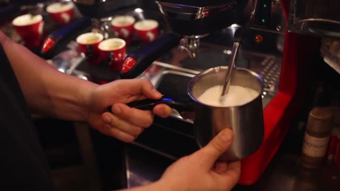 使用浓缩咖啡机在金属玻璃瓶中蒸牛奶