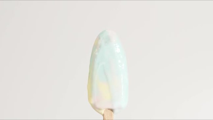 彩虹味冰淇淋冰棒融化在白色背景上。