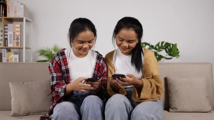 亚洲双胞胎女孩看智能手机