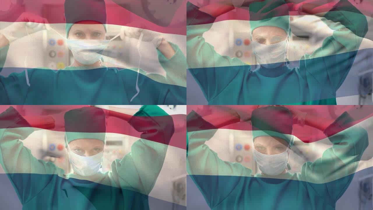 荷兰国旗在医院挥舞着戴着口罩的高加索女外科医生