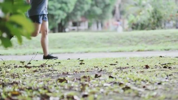 周末早上在公园慢跑的侧视图慢动作低段亚洲中国中年男子腿