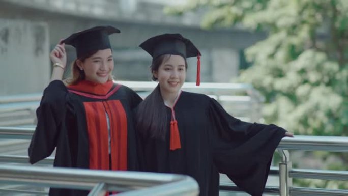 两个美丽的女人在城市庆祝毕业。