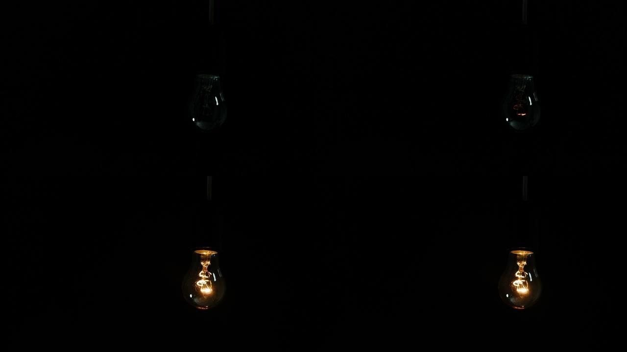 两个灯的经典白炽灯的特写镜头。玻璃灯泡、惰性气体和钨丝。柔和的自然光。灯天鹅绒效果。越来越亮。超宏。