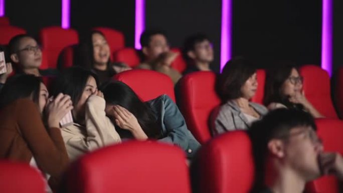 3名亚洲华裔女性在电影院电影院观看恐怖恐怖惊悚电影，并与其他观众面对面