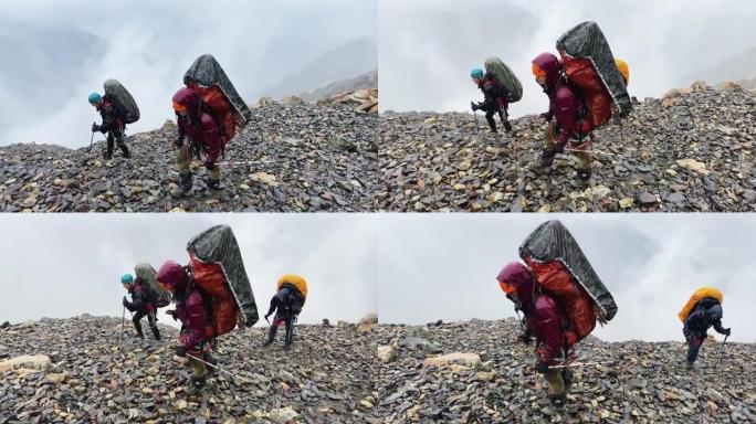 大背包湿透的游客在大雨中走在湿滑的石头上