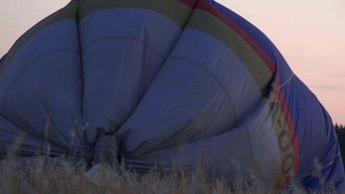 飞行员在热气球上调节火焰。热气球充气。吹热气球。准备起飞的热气球特写。火焰升起并膨胀热气球。