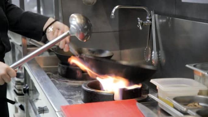 厨师的手将炒锅放在燃气灶上，以在烹饪前将其加热