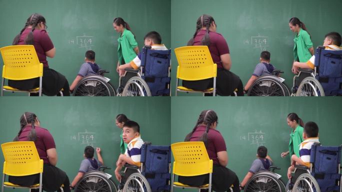 十几岁的唐氏综合症女孩看起来像朋友，用轮椅上的残疾学童组来划分数字，亚洲美女老师站在那里鼓励他们感受