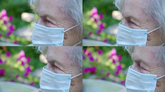 冠状病毒大流行期间，一位戴着防护口罩的老妇人在花园里的特写镜头