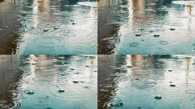 4k雨滴落下并在水坑中形成水环的特写镜头