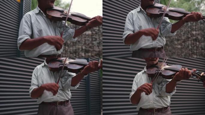 年长的白人男子在户外专业地挥舞着小提琴，为每个听到他的音乐的人提供了一天的好心情。