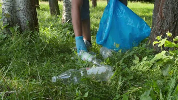 年轻人在公园或森林中收集塑料垃圾，交通缓慢。志愿者收集塑料垃圾。环保志愿者正在清扫乡村。