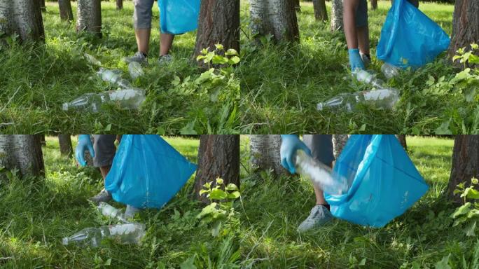 年轻人在公园或森林中收集塑料垃圾，交通缓慢。志愿者收集塑料垃圾。环保志愿者正在清扫乡村。