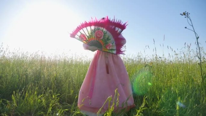 穿着民族服装的韩国女子在草地上跳舞扇子舞