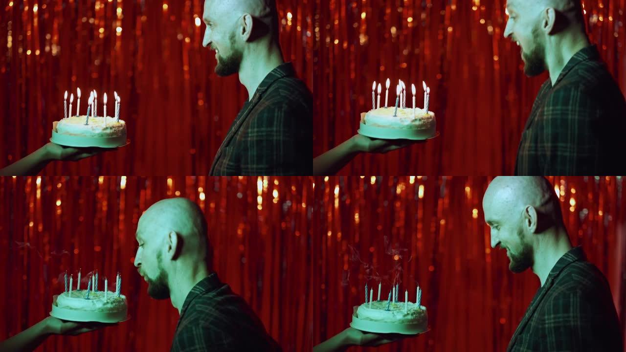 生日快乐兴奋的男人在蛋糕上吹蜡烛