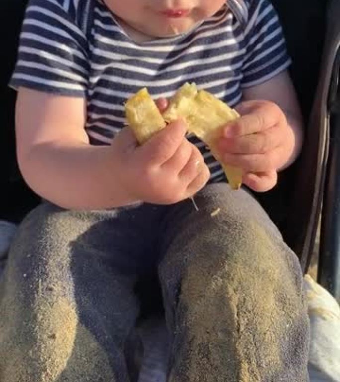充满沙子的婴儿用香蕉皮弄脏了