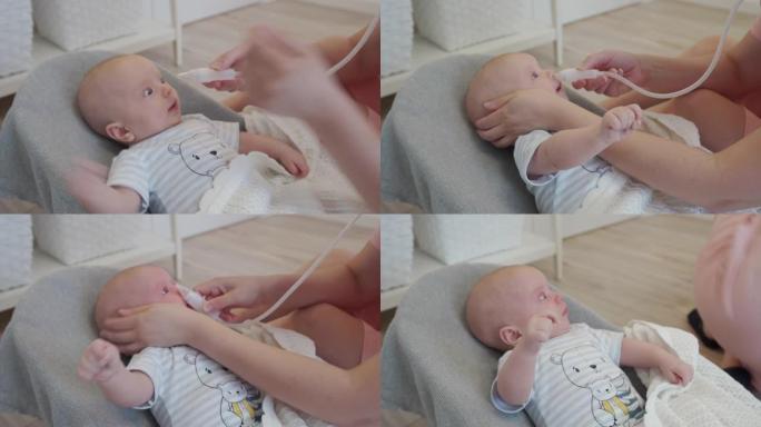 用灯泡注射器抽吸儿童鼻塞，母亲用抽吸导管清除婴儿鼻子上的粘液。