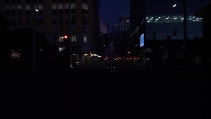 市中心城市街道背景在黎明前的黑暗夜晚，街道和过往的汽车在黑暗背景下照明