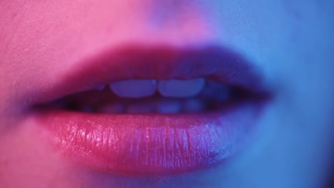 霓虹灯下性感的女性嘴唇。女人性感地张开嘴。