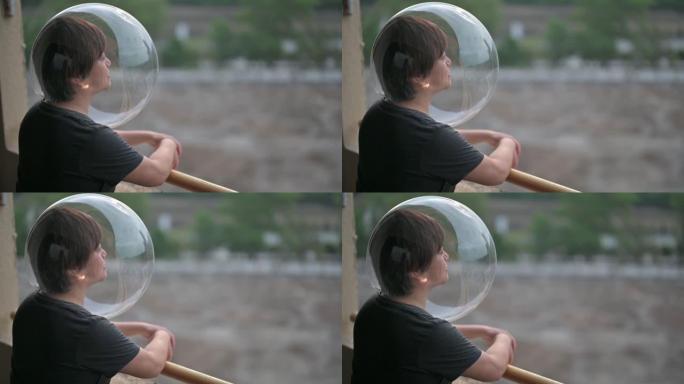 创意肖像后视图亚洲华人中成年女性戴着透明的全头盔从阳台看风景