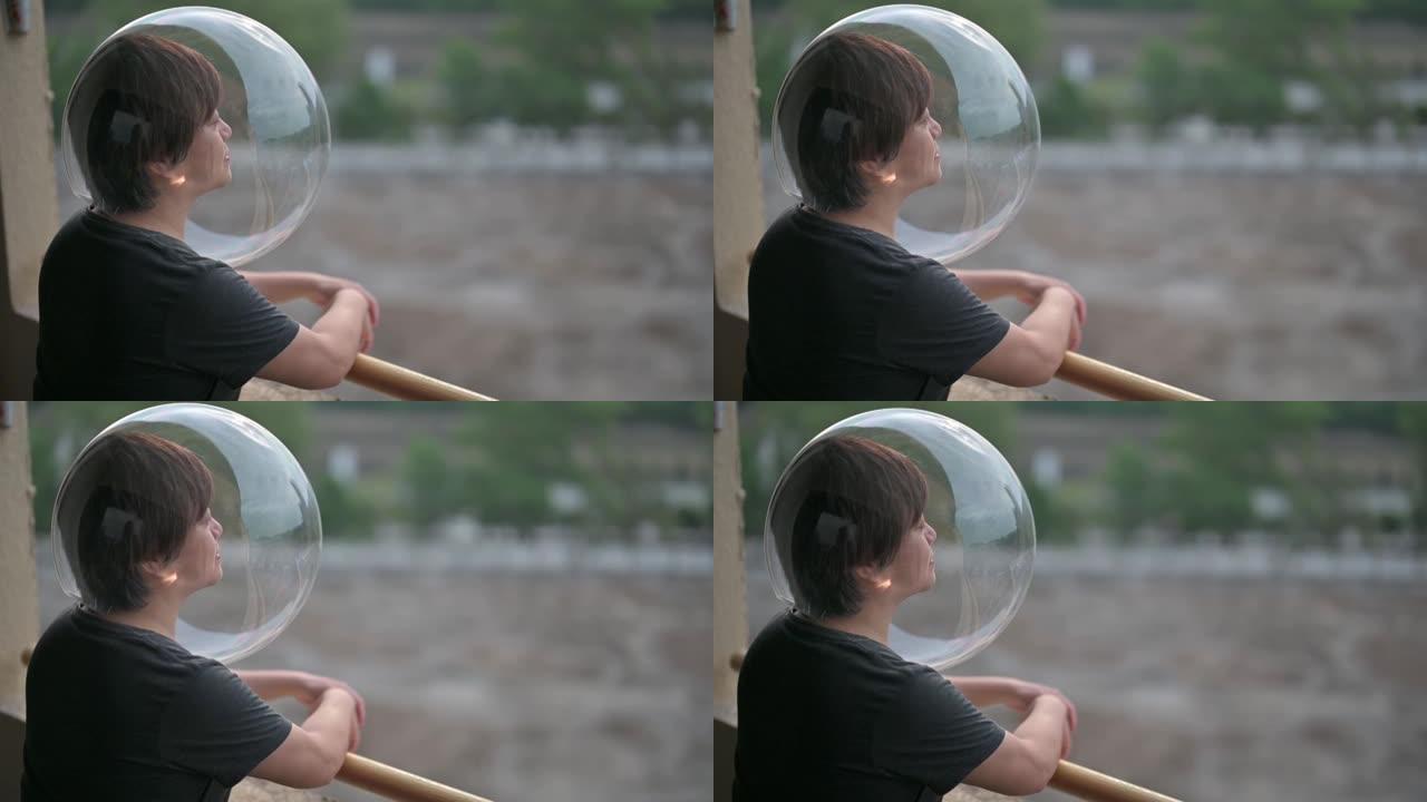 创意肖像后视图亚洲华人中成年女性戴着透明的全头盔从阳台看风景