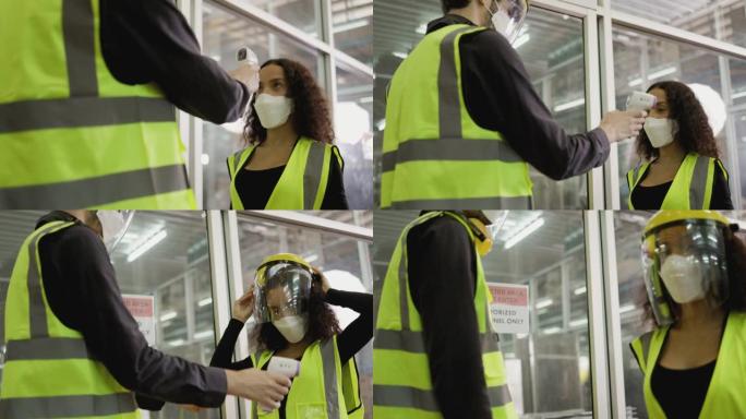 工人进入工作工厂前的温度检查站，以防止covid19。女性戴口罩保护冠状病毒。合作在工业工厂工作。值
