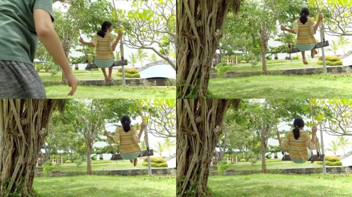 快乐的亚洲儿童在公园户外一起在树下玩秋千，生活方式的概念。