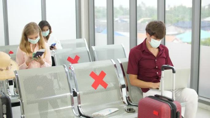 旅客在机场等候离港航班时戴防护面罩