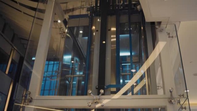 电梯在透明的竖井中移动。拍摄行驶中的电梯。