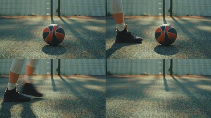近距离射门，专注于躺在室外篮球场上的球。男子捡起球，然后走开