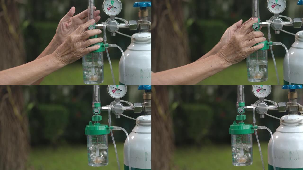 老年妇女拿着带氧气瓶的流量调节器
