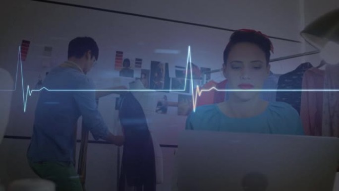 发光心率监测器的动画，超过在创意办公室使用笔记本电脑的女人