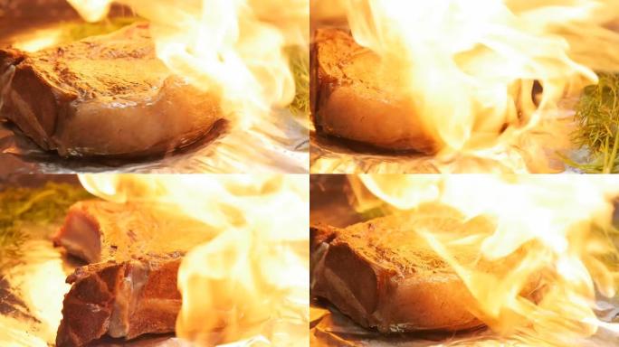 厨师用定向的火焰炸制新鲜的肉牛排，将其放在薄薄的烹饪箔纸上，然后用手旋转一块肉。特写，慢动作。