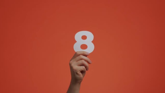 八号在手。手臂显示数字，第八个数字由雕刻纸制成，用于投票或学习