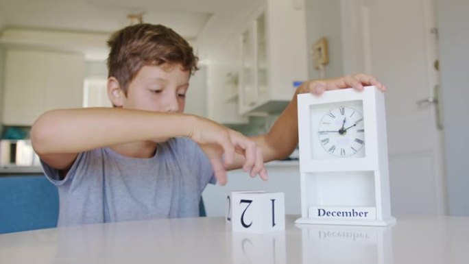 男孩把日历上的立方体放在12月25日，圣诞节。