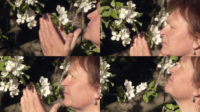 一位白人女士闻到苹果树花香的特写镜头。