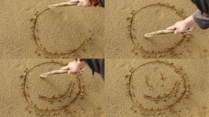 女人在沙滩上画一张笑脸。休闲。