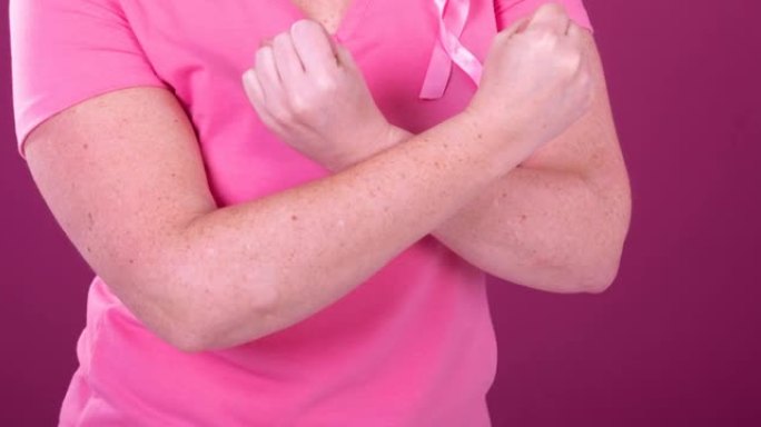 白种人妇女的腹部与交叉双臂戴粉红癌症意识丝带的视频