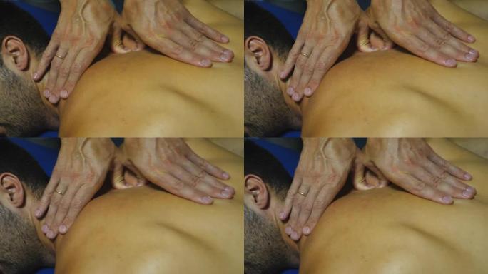 脊医男性手指的俯视图向沙龙运动员触诊脊柱椎骨。手动治疗师的手推动着年轻运动员的骨干。背部治疗的概念。